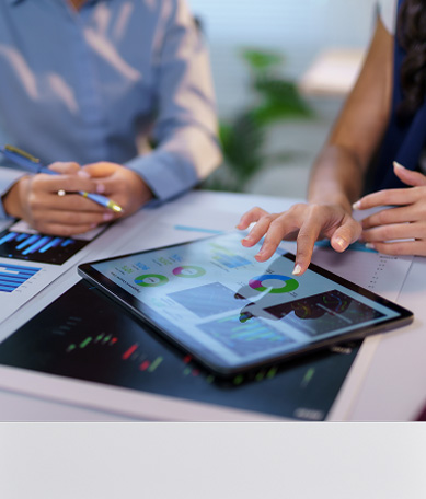 View of two financial professionals' hands while viewing data on a tablet